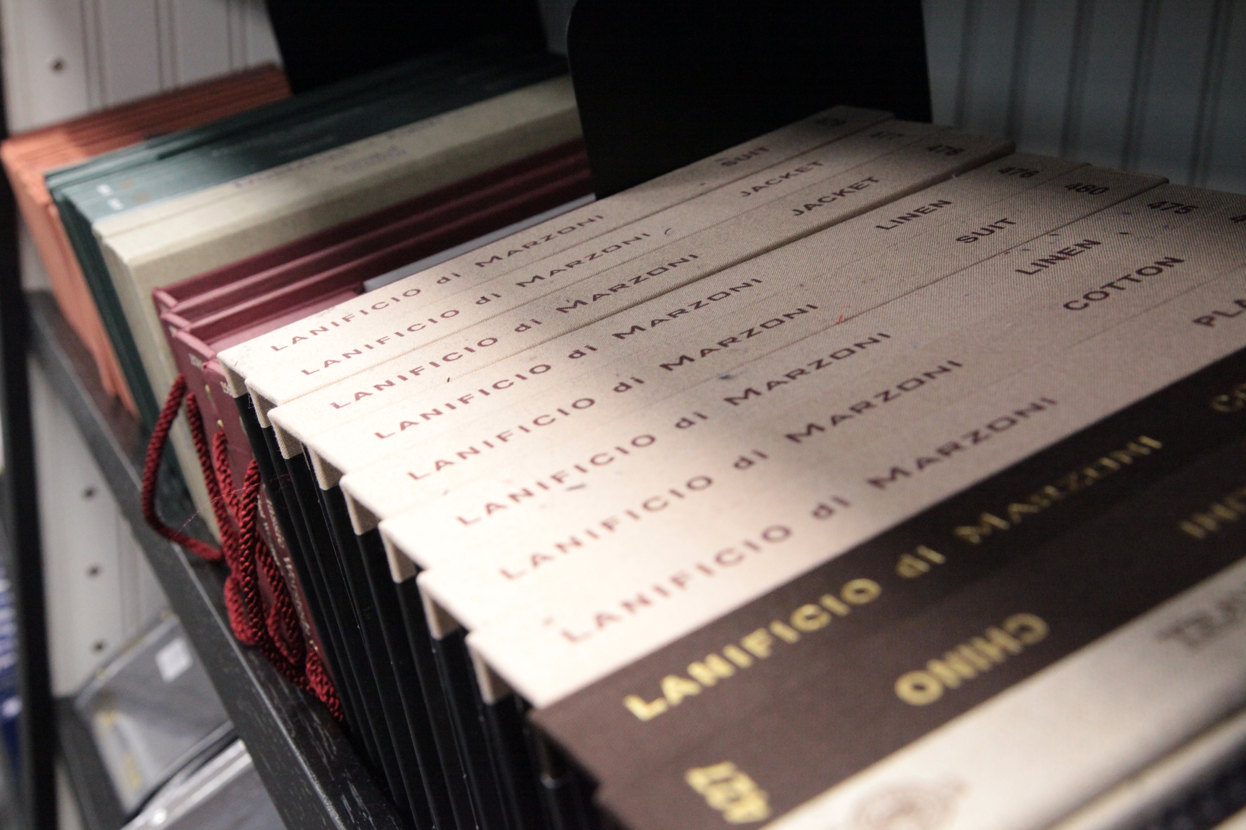 Fabric swatch books from Lanificio di Marzoni on a shelf