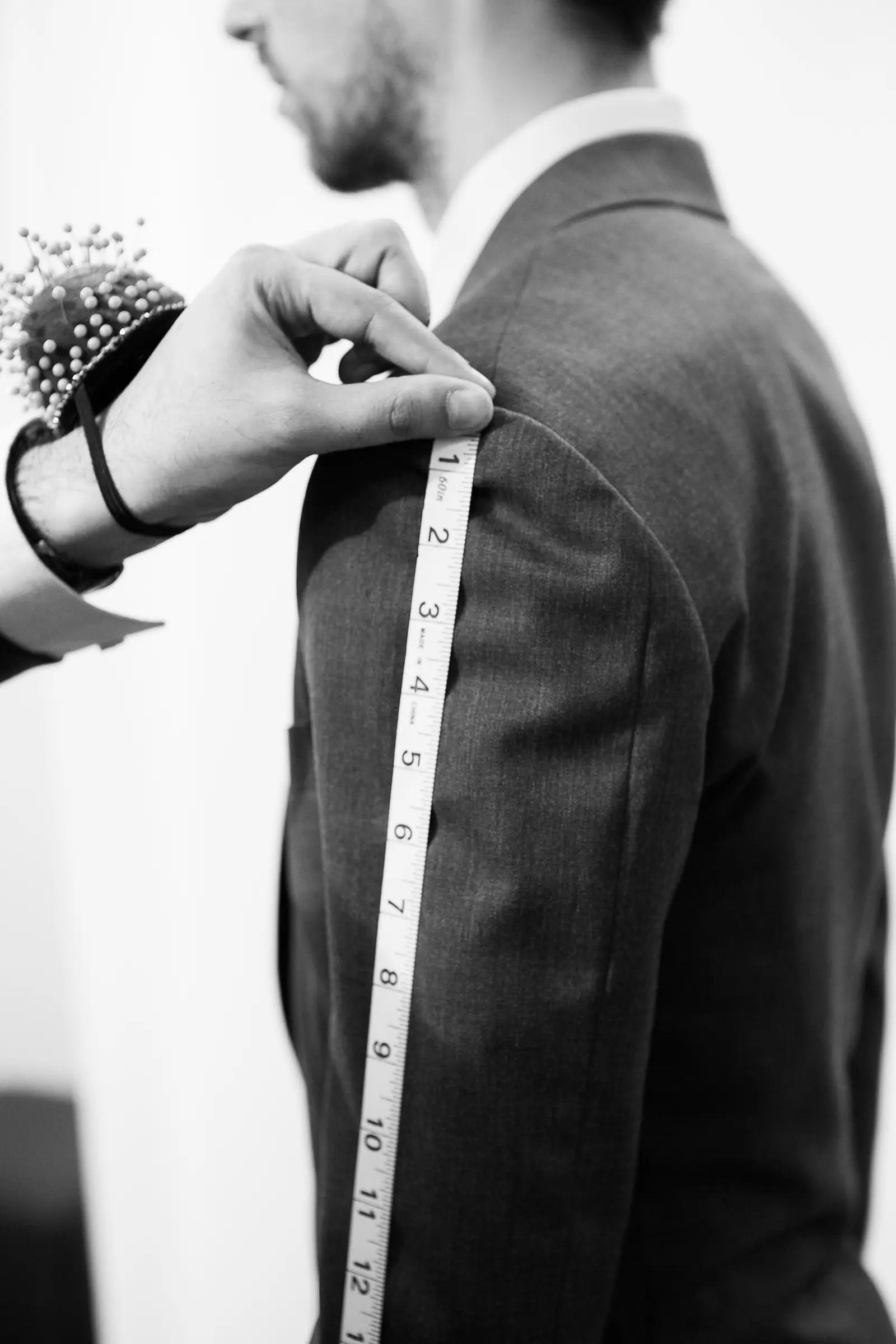 Tailor measuring a client for a custom suit